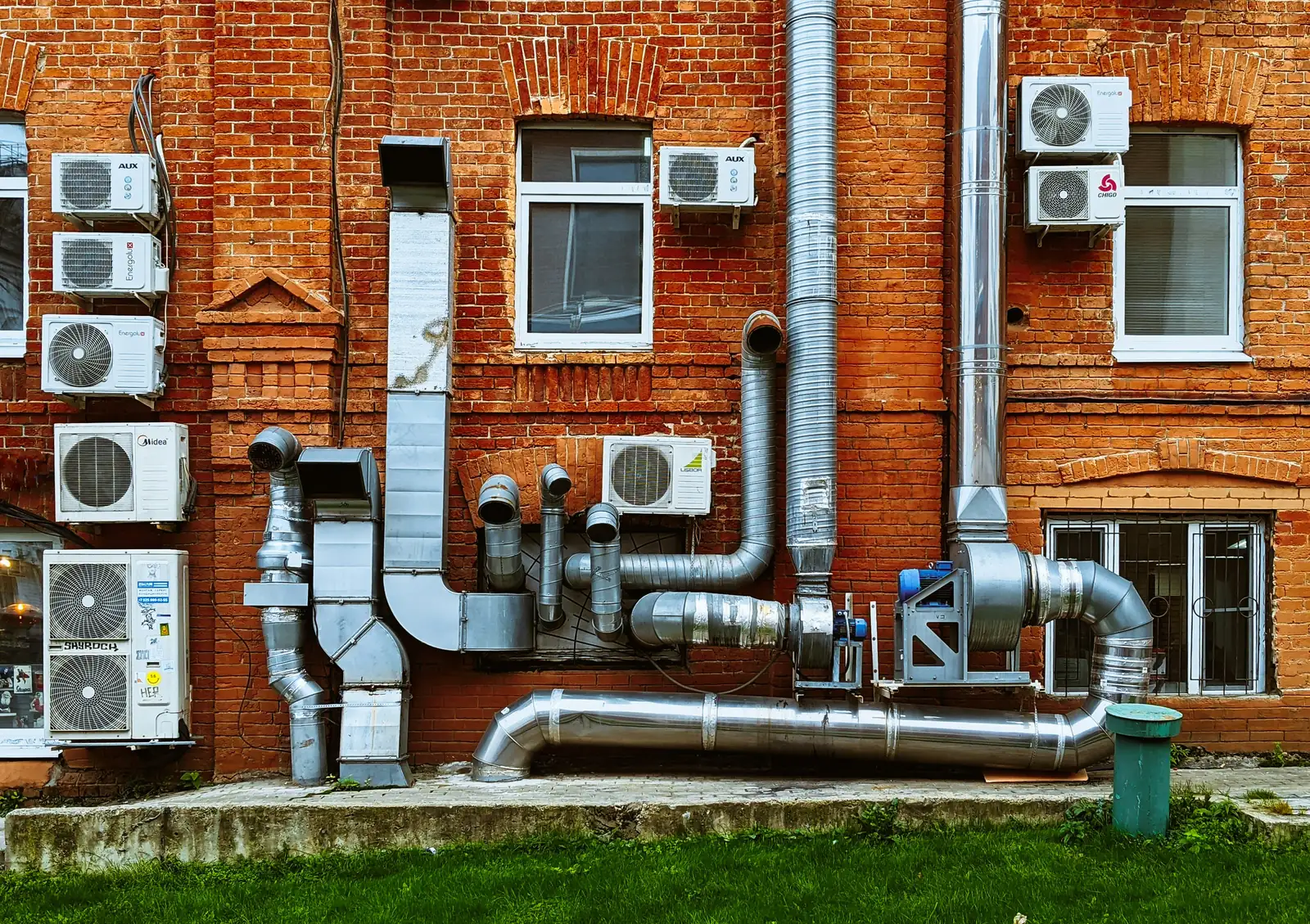 Climatiseurs muraux et conduits de ventilation sur un mur de brique